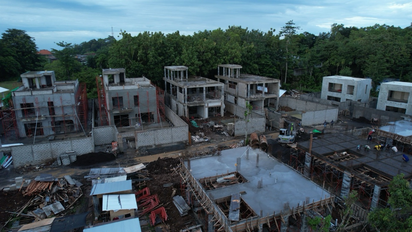 Structural shells rising across a villa estate